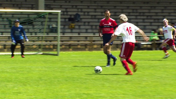 Eine Spielszene der Ü60-Mannschaftenauf dem Fußballplatz: Ein Stürmer nähert sich dem Tor und ist kurz davor, zu schießen. © Screenshot 