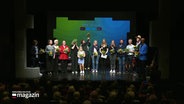 Preistägerinnen und Preisträger des Schreibwettbewerbs "Vertell doch mal" auf der Bühne © Screenshot 