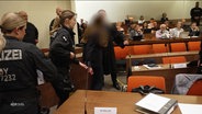 Die angeklagte Ärztin wird in den Gerichtssaal geführt. © Screenshot 