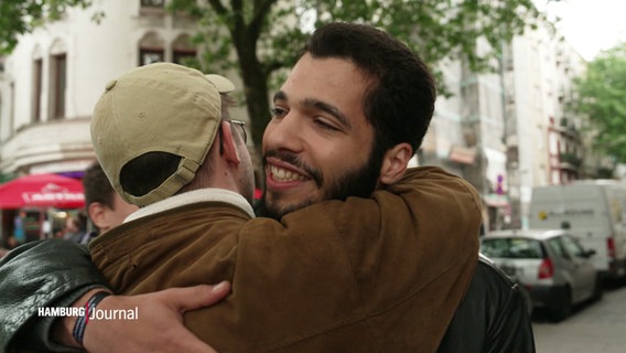 Zwei Männer umarmen sich. © Screenshot 