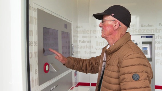 Ein älterer Mann bedient einen Fahrkartenautomaten © Screenshot 