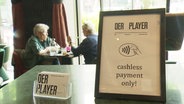 Aufsteller in einem Restaurant mit der Aufschrift "cashless payment only". © Screenshot 