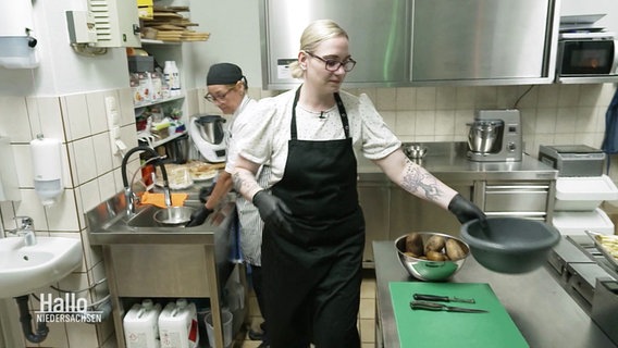 Die 38-jährige Nicole Löwen stellt in der Küche ihres Gasthofs eine schwarze Schale zum Kartoffenschälen bereit. © Screenshot 