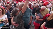 Zahlreiche Paare halten rote Herz-Luftballons in den Händen und küssen sich. © Screenshot 
