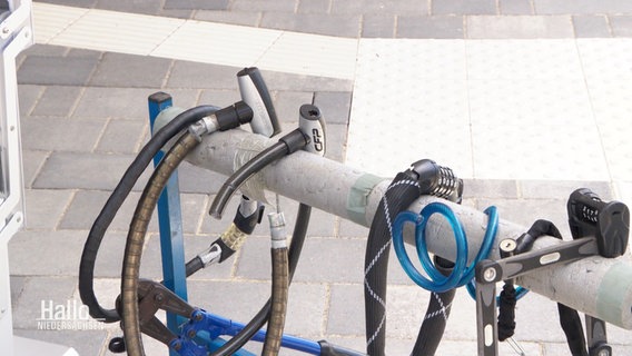 An einer Stange hägen verschiedene Fahrradschlösser nebeneinander. © Screenshot 
