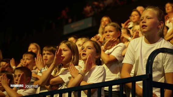 Viele singende Kinder in weißen T-Shirts. © Screenshot 