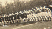 Eine alte schwarz-weiß-Aufnahme zeigt Fußballspieler, die in einer Reihe stehen und den Hitlergruß machen. © Screenshot 