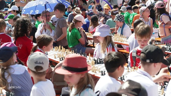 Grundschulkinder spielen auf dem Rathausmarkt Schach. © Screenshot 