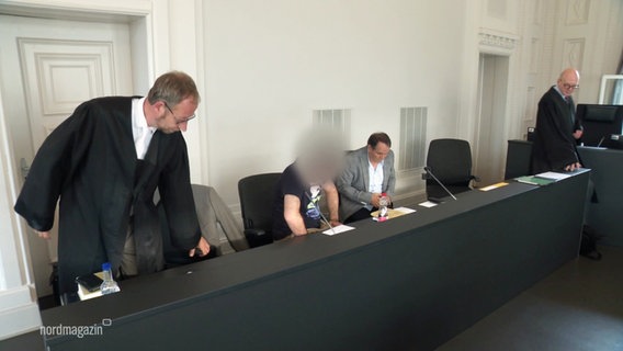 Anklagebank im Landgericht Schwerin - der Angeklagte sitzt, neben ihm steht sein Verteidiger. © Screenshot 