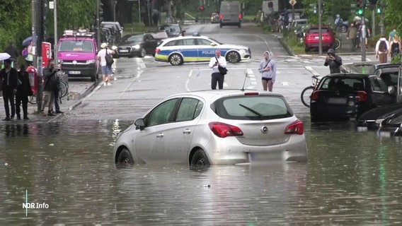 Ein Auto auf einer überfluteten Straße. © Screenshot 