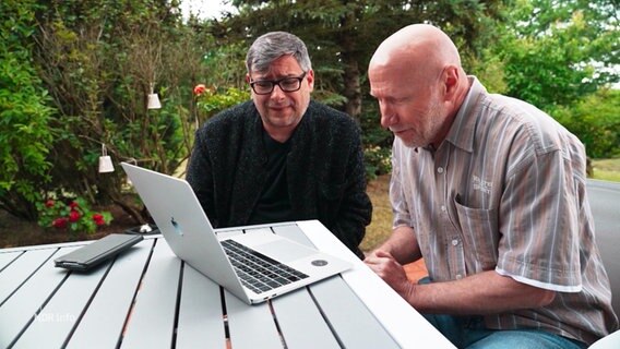 Zwei Personen betrachten ein Laptop. © Screenshot 