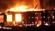 Ein Reetdachhaus steht in Flammen. © Screenshot 