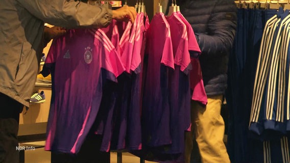 Auf einem Kaufhausständer hängen mehrere pink-lila Trikots des deutschen Fußballnationalteams © Screenshot 