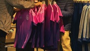 Auf einem Kaufhausständer hängen mehrere pink-lila Trikots des deutschen Fußballnationalteams © Screenshot 