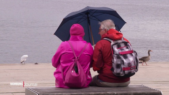 Ein Paar unter einem Regenschirm am Jungfernstieg. © Screenshot 