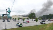 Rauchwolken steigen aus einer Lagerhalle der Lürssen-Werft. © Screenshot 