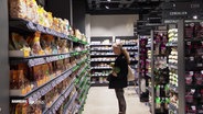 Eine Person steht vor einem Regal in einem Supermarkt. © Screenshot 
