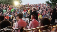 Heinz Rudolf Kunze und die Bundeswehr Big Band vor Publikum bei einem Benefizkonzert. © Screenshot 
