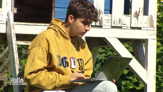 Ein junger Mann schaut auf einen Laptop. © Screenshot 