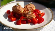 Auf einem Teller sind Grießknödel mit Amarettini und Erdbeeren angerichtet. © Screenshot 