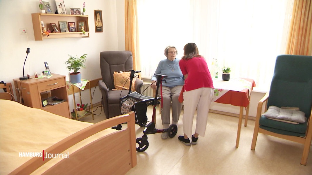Eine Pflegerin spricht mit einer älteren Dame. 