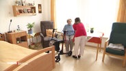 Eine Pflegerin spricht mit einer älteren Dame. © Screenshot 