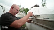 Andreas Klier führt Reparaturarbeiten an einem Boot aus. © Screenshot 