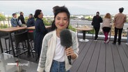 NDR Reporterin Annette Yang spricht in ein Mikrofon © Screenshot 