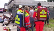 Mehrere Rettungskräfte stehen um eine Frau herum © Screenshot 