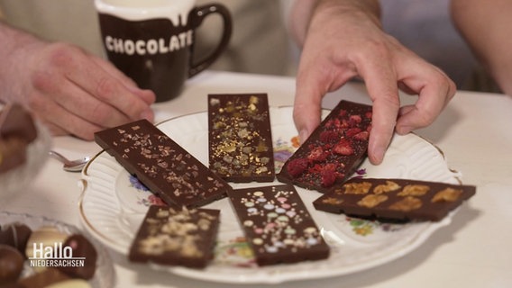 Auf einem Teller liegen sechs Tafeln Schokolade. © Screenshot 