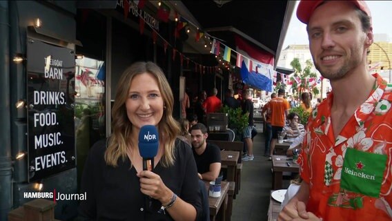 Reporterin Hanna Bird und ein niederländischer Barbesitzer. © Screenshot 