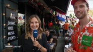 Reporterin Hanna Bird und ein niederländischer Barbesitzer. © Screenshot 