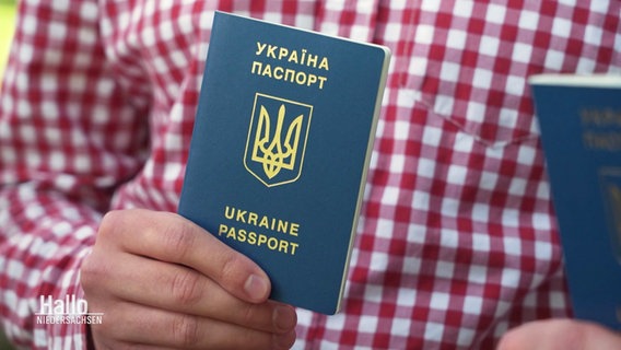 Eine Hand hält einen ukrainischen Pass. © Screenshot 