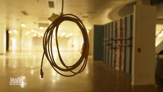 Ein zusammengerolltes Kabel hängt von der Decke. © Screenshot 