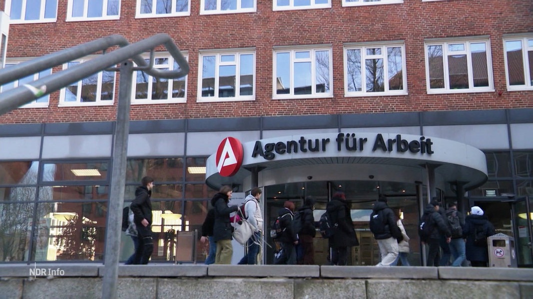 Ein Eingang der Agentur für Arbeit, davor ein paar Menschen.