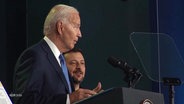 US-Präsident Joe Biden am Rednerpult, im Hintergrund der ukrainische Präsident Selenskij. © Screenshot 
