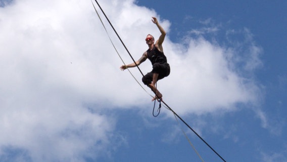 Der Highline-Artist Ian Eisenberg balanciert auf einem schmalen Seil. © Screenshot 