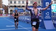 Ein Triathlon-Teilnehmer läuft am Hamburger Rathausmarkt durchs Ziel. © Screenshot 