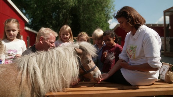 Mariana Martins füttert mit einer Gruppe von Kindern ein Pony. © Screenshot 