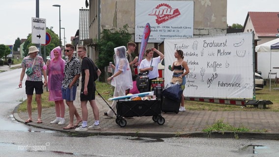 Festivalbesucher ziehen mit einem Bollerwagen zum Einkauf durch Neustadt-Glewe. © Screenshot 
