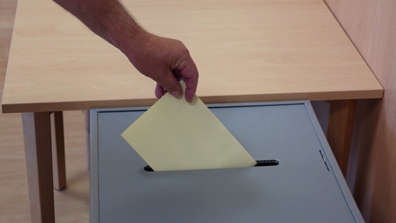 Ein Stimmzettel wird eingeworfen © Screenshot 