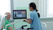 Pflegerin Thi Kim Dung Ngyuen spricht auf Station mit einer Patientin. © Screenshot 