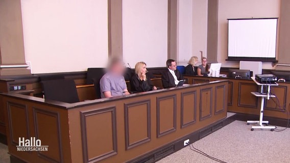 Angeklagte mit unkenntlich gemachtem Gesicht während des Gerichtsverhandlung. © Screenshot 