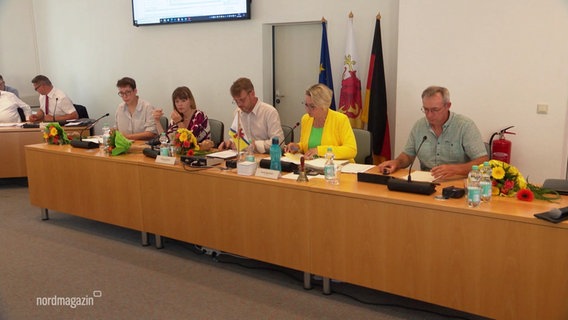 Frischgewählte Politiker:innen sitzen an einem langen Tisch im Kreistagsparlament Vorpommern-Greifswald. © Screenshot 