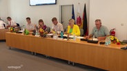 Frischgewählte Politiker:innen sitzen an einem langen Tisch im Kreistagsparlament Vorpommern-Greifswald. © Screenshot 