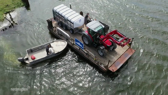 Ein Traktor setzt auf einer Fähre über ein Gewässer über. © Screenshot 