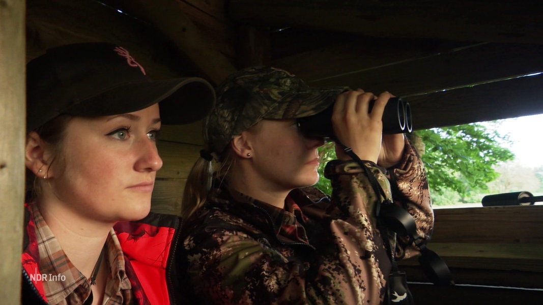 Die Jägerinnen Alisa Kamrath-Maschmann (vorne) und Anna Breiholz sitzen in einem Hochsitz und halten Ausschau nach Tieren.