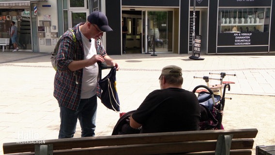 Ein Streetworker spricht mit einem Mann auf einer Bank. © Screenshot 