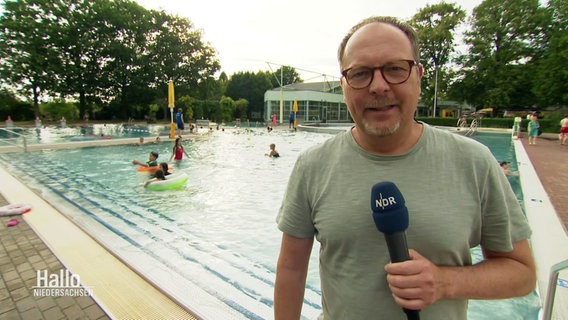 Reporter Oliver Köhler steht am Becken eines Freibades. © Screenshot 
