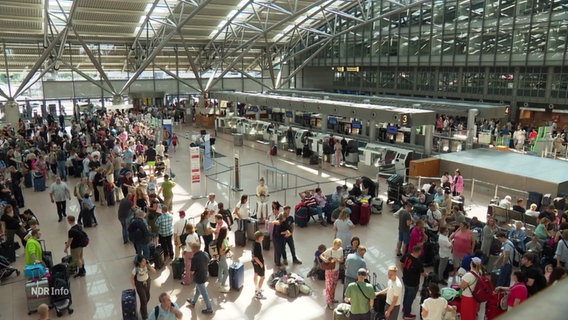 Fluggäste in der Schalterhalle des Hamburger Flughafens. © Screenshot 